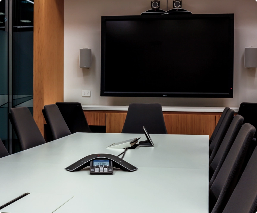 Meeting space with a dial-in system, two cameras, and a TV mounted on the wall.