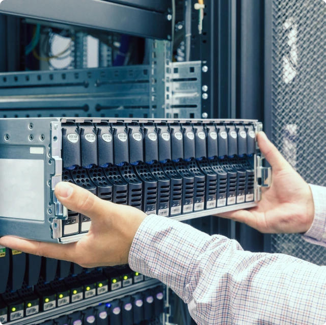 A man's hands pulling a portion of a data center out of the closet.