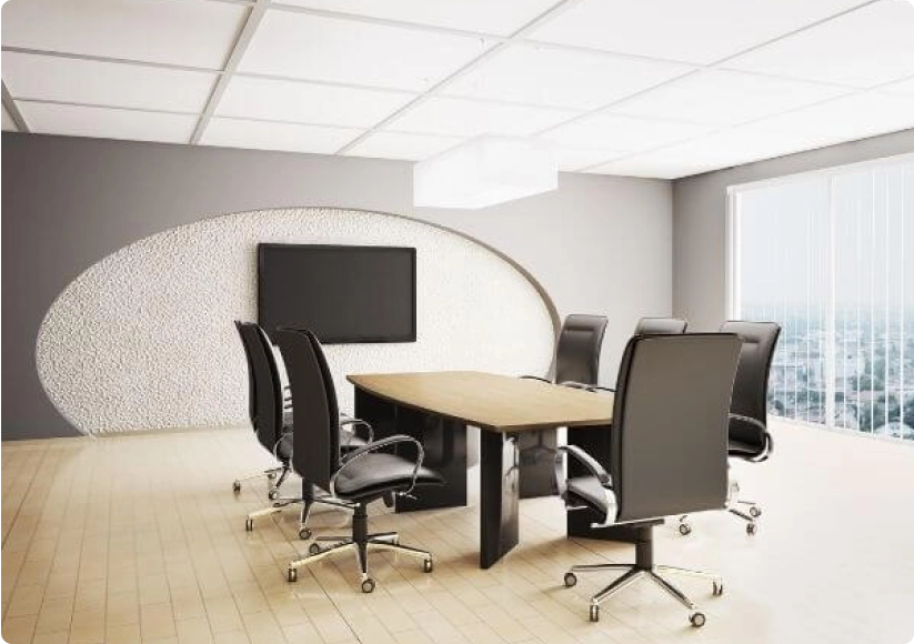 Modern meeting room with 7 chairs at a table and a large TV on the wall.